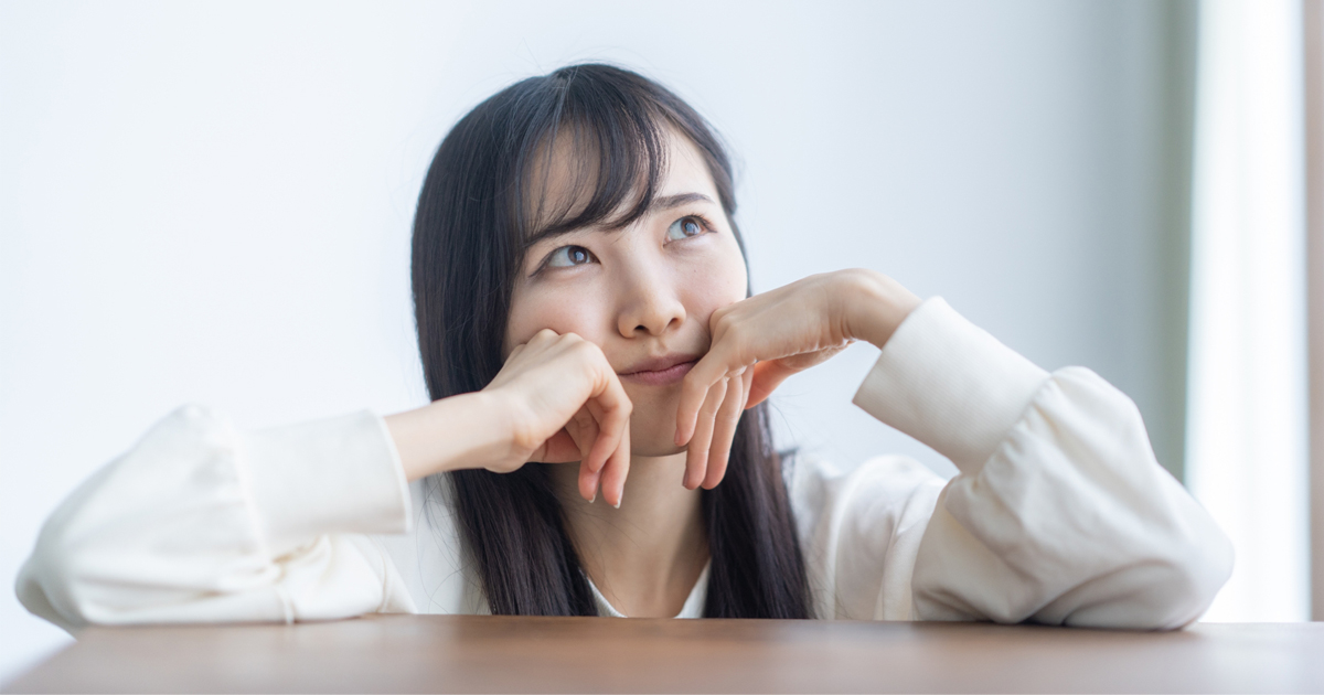 悩んでいる白いブラウスを着た女性